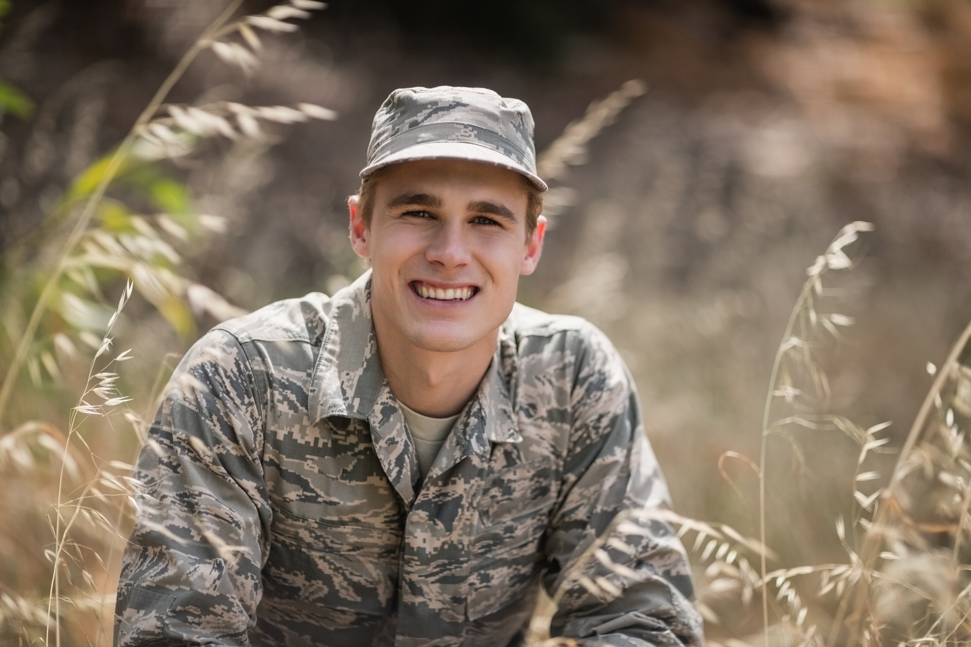Military soldier crouching in grass